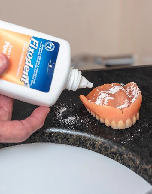 Adhesive being applied to a removable denture